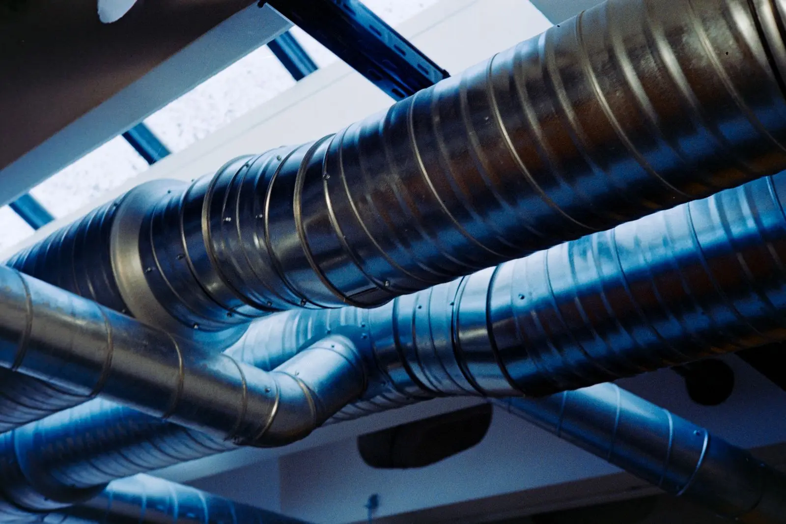 Galvanised steel ducted air-conditioning ductwork running along a modern ceiling